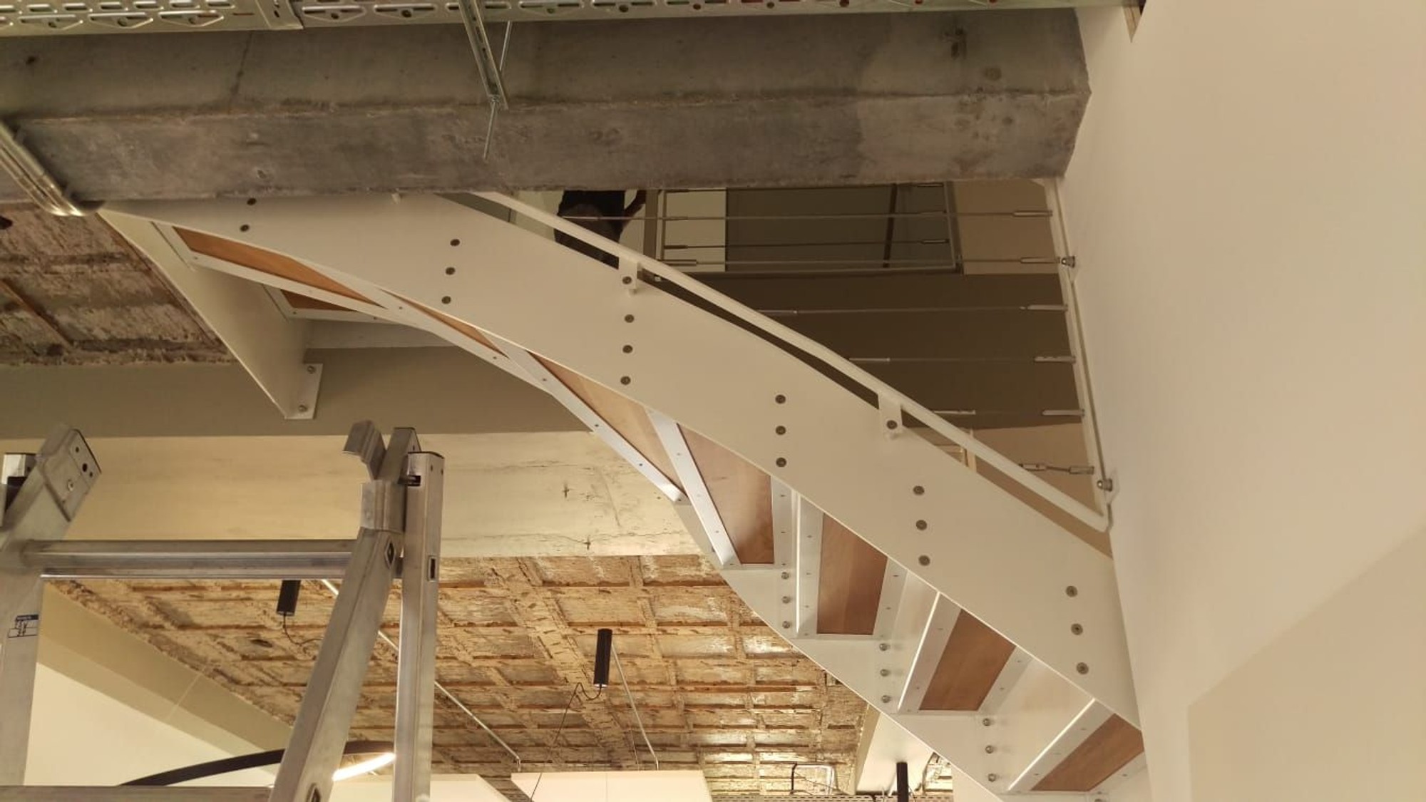 Filigrane Stahlstruktur mit warmen Holzstufen